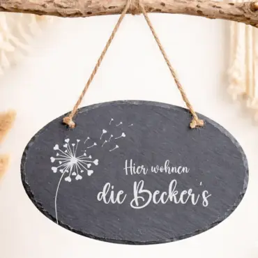 Gartenschild personalisiert: ovales Schieferschild mit Pusteblume und Familiennamen hängt an einem Ast